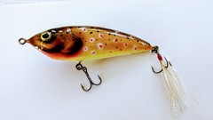 Hand carved bass wood surface lure painted in brown trout .